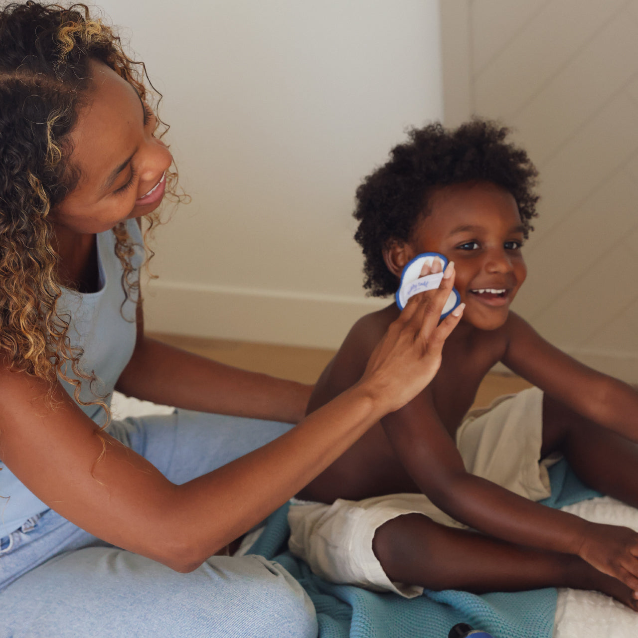 Mama applying Micellar water to her son's face